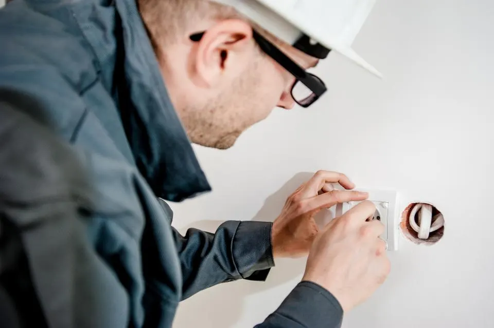 Électricien posant une prise murale